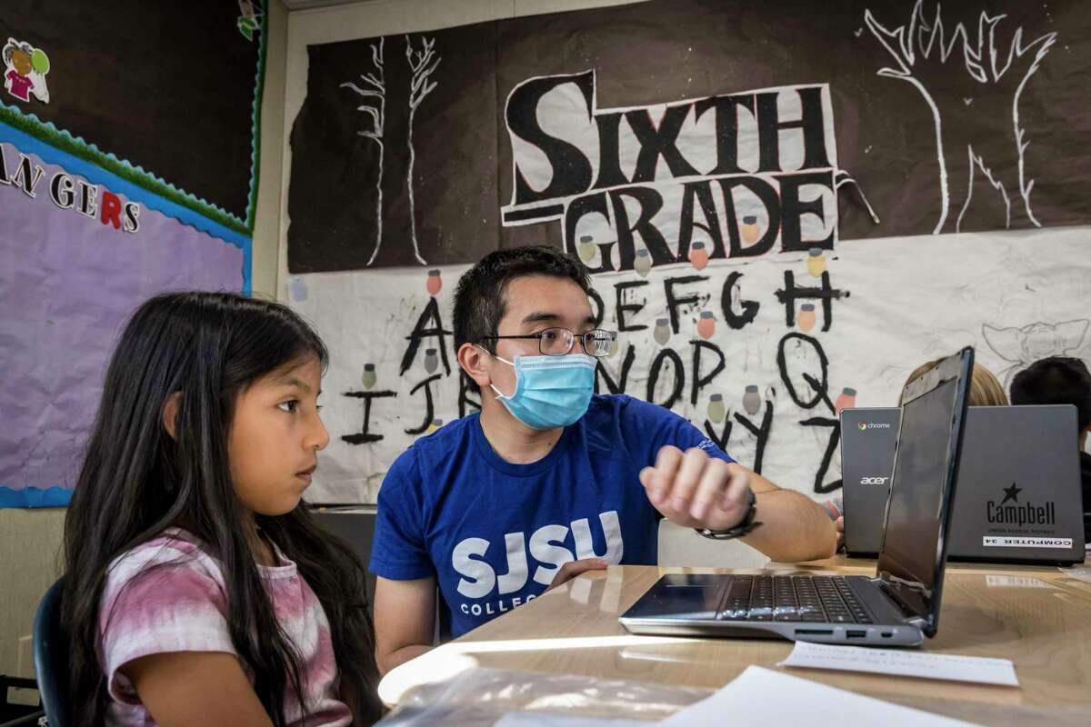 William Ngo works with Daniela Cruz during a tutoring session at Sherman Oaks Elementary in San Jose. California is launching its first-of-its-kind program that allows needy students to earn $10,000 for their education in exchange for service-oriented jobs.