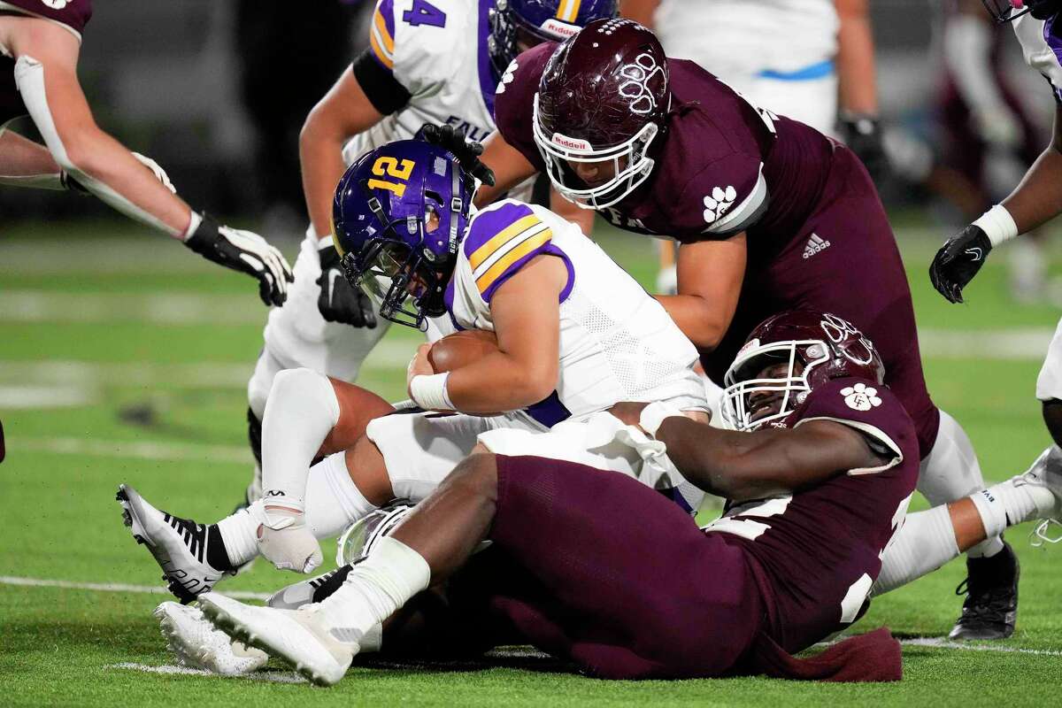 Cy-Fair defensive lineman Ethan Anderson, bottom, sacks Jersey Village quarterback Adam Tran (12) during the second half of a high school football game, Friday, Sept. 30, 2022, in Houston.