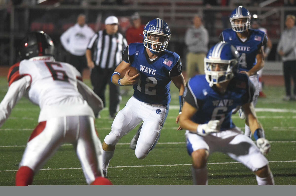 Darien's Jake Wilson (12) runs for some of his 188 yards against Warde during a football game in Fairfield on Friday, Sept. 30, 2022.