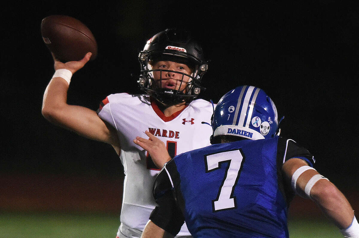 Warde's Charlie Gulbin (4) throws a pass while under pressure from Darien's Layton Reesor (7) during a football game in Fairfield on Friday, Sept. 30, 2022.