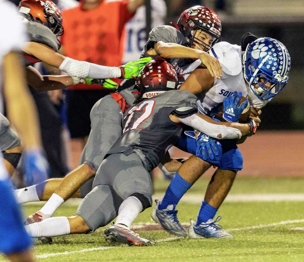 South San Antonio’s Joseph Salinas, right, is tackled Friday night, Sept. 30, 2022, by Southside defenders during the first half of the Cardinals’ homecoming game against the Bobcats.