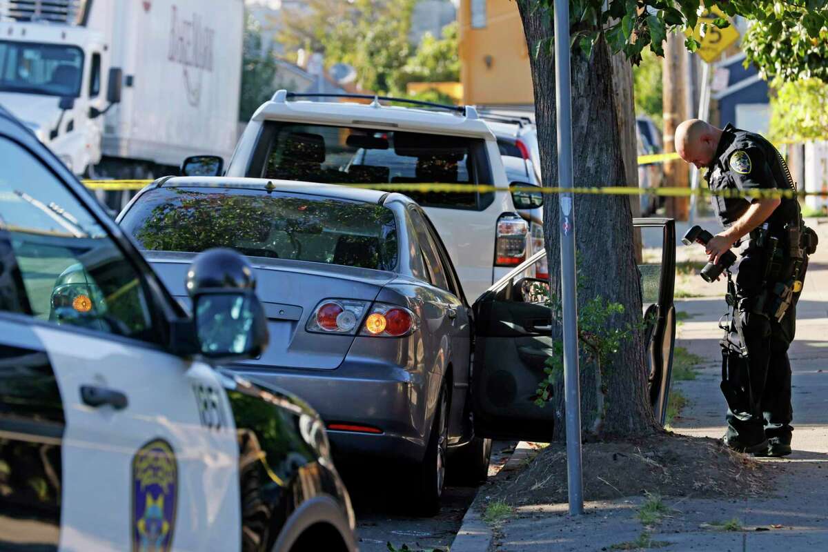 Police collect evidence at a vehicle that’s riddled with bullets and blood splatter after a shooting occurred earlier today along Masterson Street between 38th and 39th avenues in Oakland, Calif., Friday, Sept. 30, 2022.