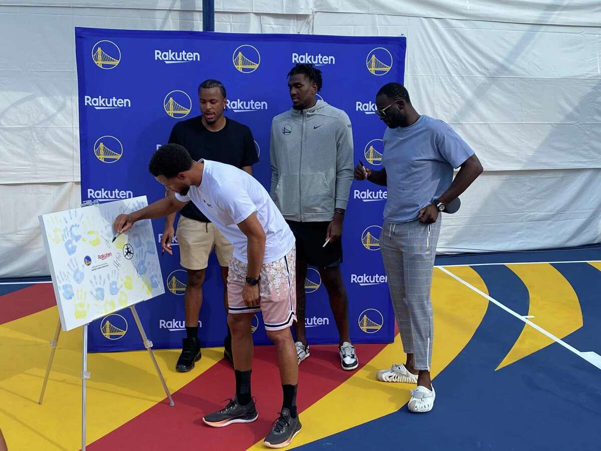 From left, Stephen Curry, Moses Moody, Kevon Looney and Draymond Green take part in an unveiling of a refurbished basketball court at the Ikenoue Youth Exchange Center in Tokyo’s Setagaya Ward on Saturday, Oct. 1, 2022.