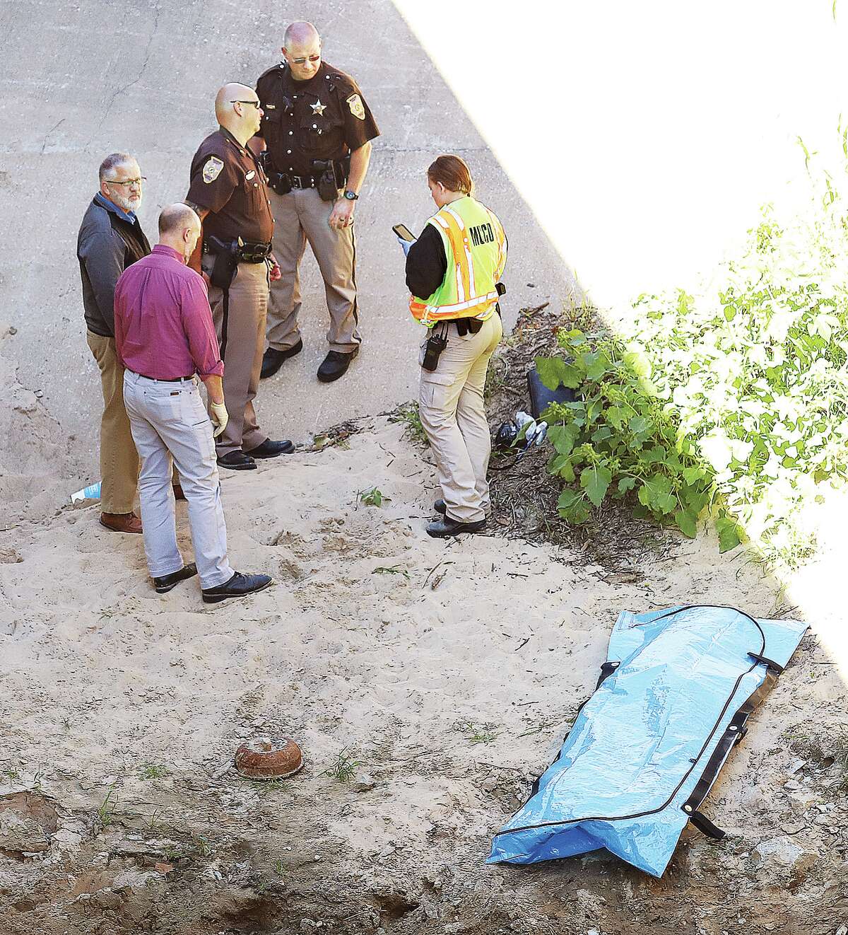 John Badman|The Telegraph Madison County deputies and a Madison County Coroner's Office investigator prepare to retrieve a deceased person found in Cottage Hills Saturday.