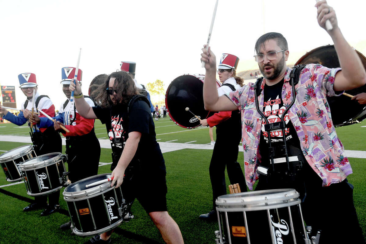 Adam King, class of 2005 (right), and Tyler Haynes, class of 2011, join the drum line in a rousing opening number during the alumni game against Atascocita Friday night at Memorial Stadium. Photo made Friday, September 30, 2022 Kim Brent/Beaumont Enterprise