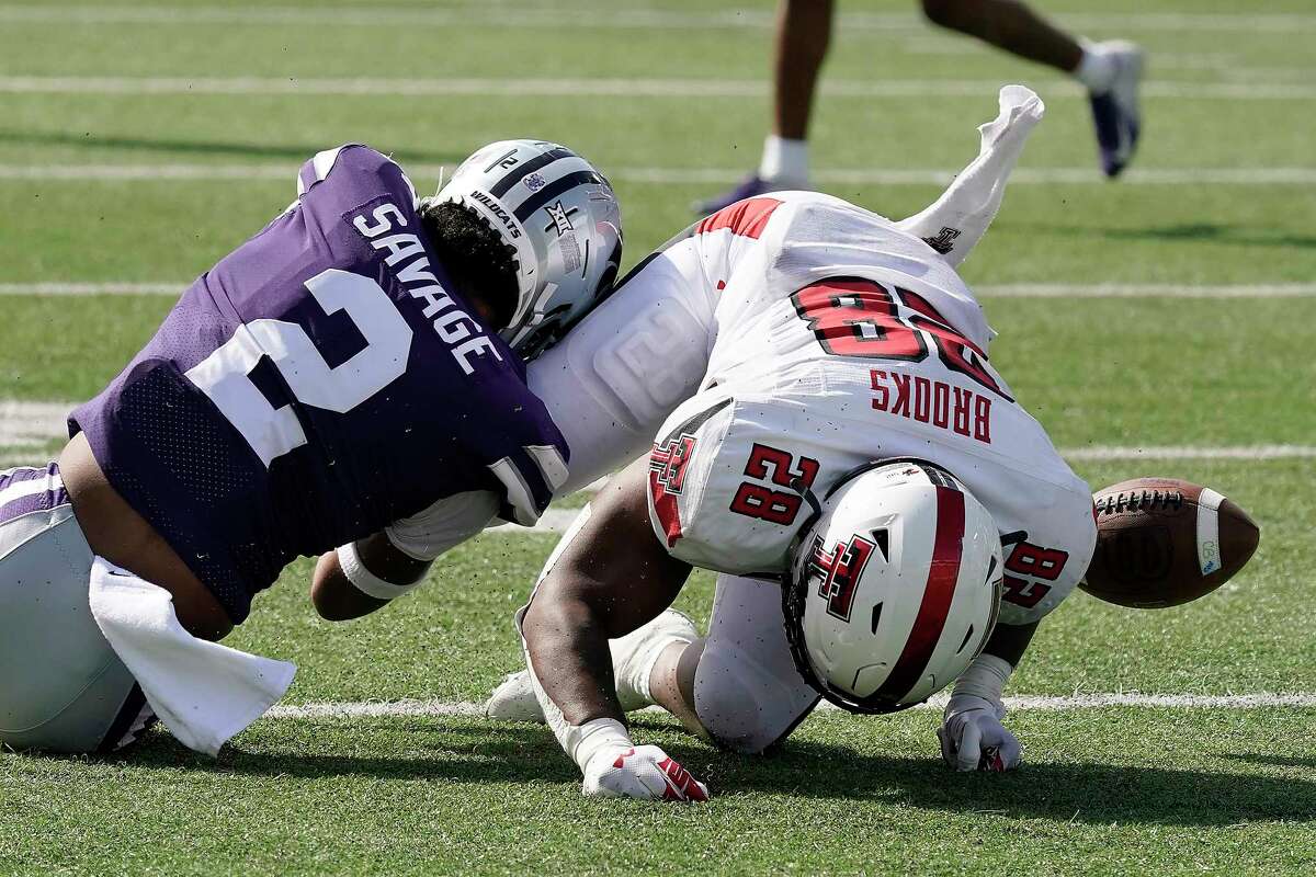 Texas Tech running back Tahj Brooks (28) fumbles the ball after being tackled by Kansas State safety Kobe Savage (2) during the first half of an NCAA college football game Saturday, Oct. 1, 2022, in Manhattan, Kan.