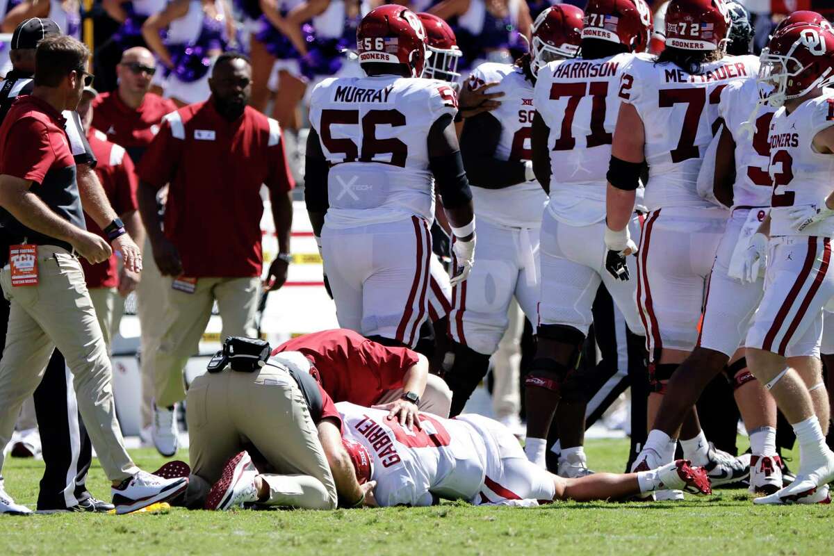 Oklahoma quarterback Dillon Gabriel (8) its looked at by team staff after a late hit by TCU during the first half of an NCAA college football game Saturday, Oct. 1, 2022, in Fort Worth, Texas.
