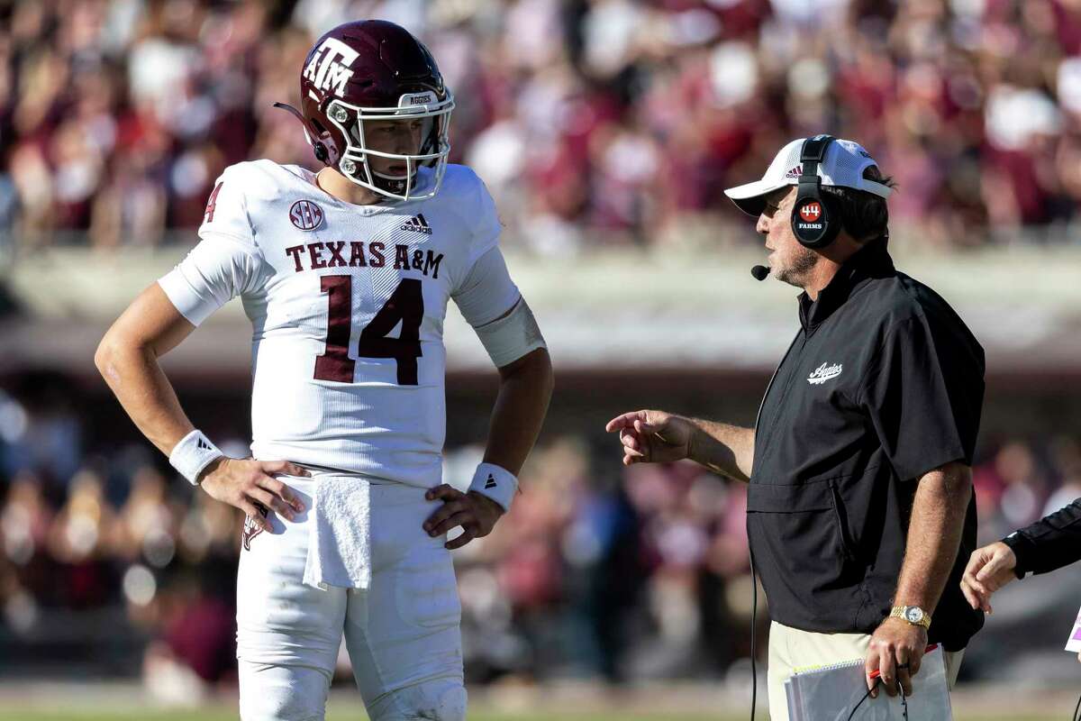 Texas A&M head coach Jimbo Fisher talks with Texas A&M quarterback Max Johnson (14) during an NCAA football game against Mississippi State, Saturday, Oct. 1, 2022, in Starkville, Miss. (AP Photo/Vasha Hunt)