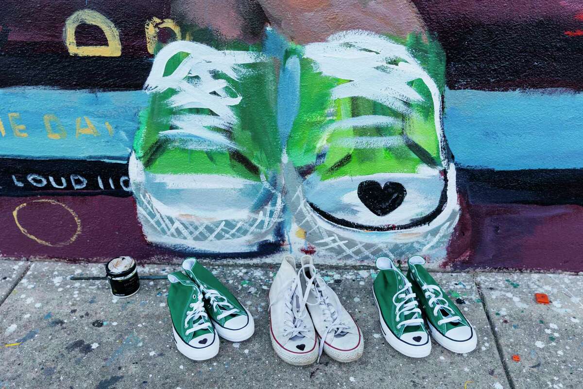 Three pairs of Converse Chuck Taylor All Star Hi-Tops sit under the mural honoring 10-year-old Maite Yuleana Rodriguez, one of the 21 people killed in the May 24 Robb Elementary School shooting, in Uvalde, Texas, Tuesday, July 26, 2022. Maite’s mother Ana Rodriguez drew black hearts on the shoes to match what the fourth grader was wearing when she died as a gift for the San Antonio based artists Ana Hernández and Gabi Magaly, who worked on the mural.