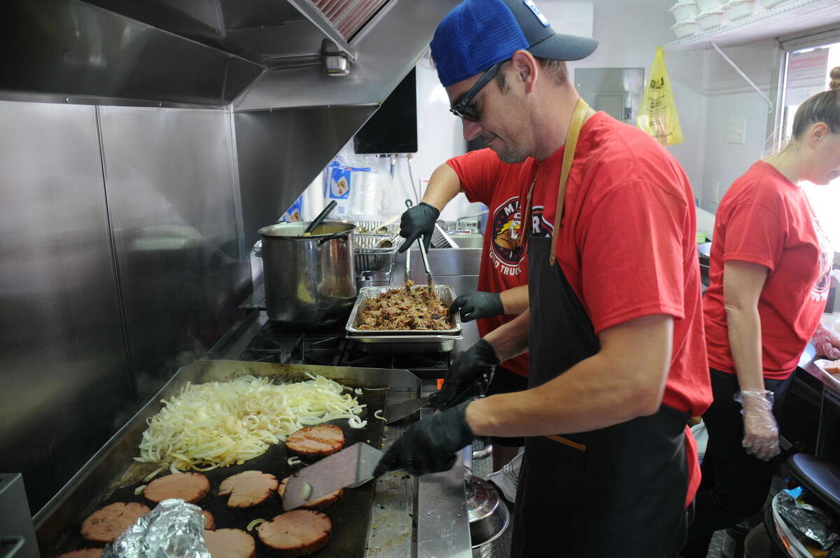 Luke Vidakovich cooks up customer orders in the Mericue truck during Saturday's Wood River Food Truck Festival.