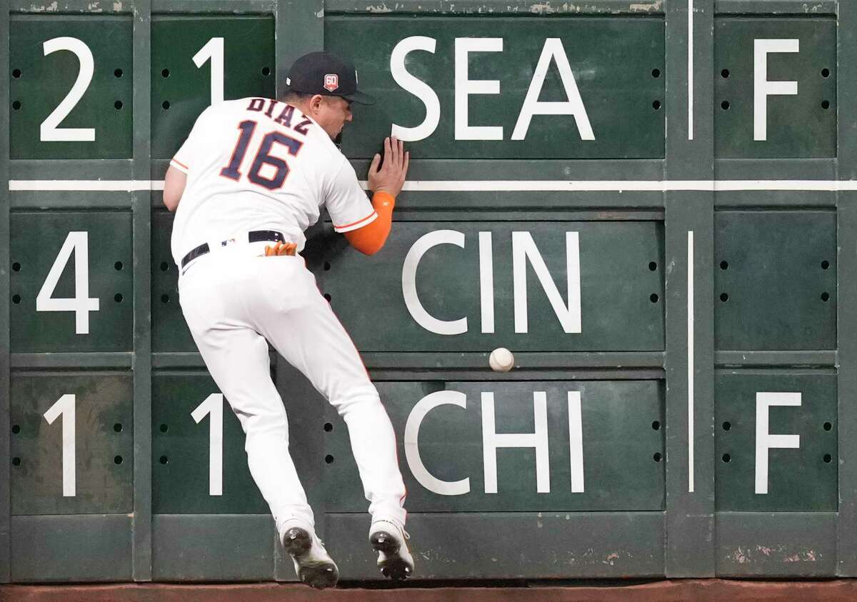 Houston Astros left fielder Aledmys Diaz (16) crashes into the outfield wall after chasing a double by Tampa Bay Rays Ji-Man Choi in the seventh inning of a MLB baseball game at Minute Maid Park on Saturday, Oct. 1, 2022, in Houston.
