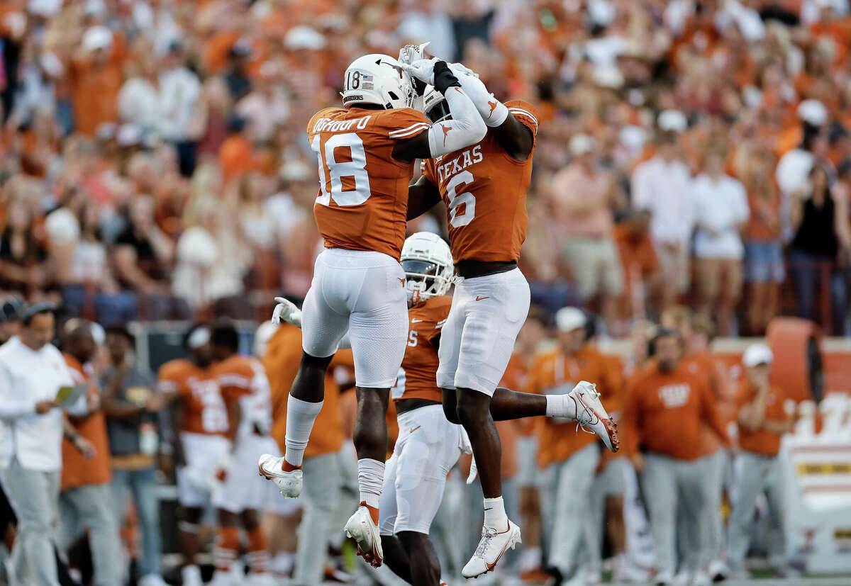 AUSTIN, TEXAS - OCTOBER 01: Ovie Oghoufo #18 of the Texas Longhorns celebrates with Ryan Watts #6 after a pass defense in the first half against the West Virginia Mountaineers at Darrell K Royal-Texas Memorial Stadium on October 01, 2022 in Austin, Texas. (Photo by Tim Warner/Getty Images)