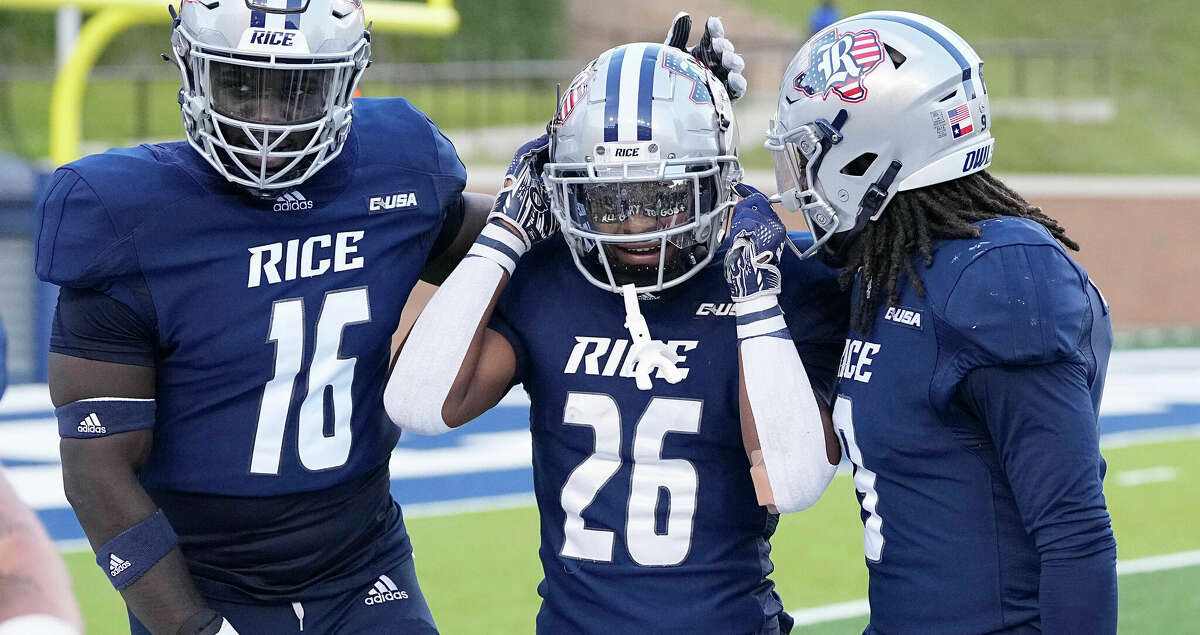 Rice Owls defensive back Gabe Taylor (26) is congratulated by Chibby Nwajuaku and Kirk Lockhart after intercepting a pass in the first quarter of a football game against the UAB Blazers in Houston, Saturday, Oct. 1, 2022.