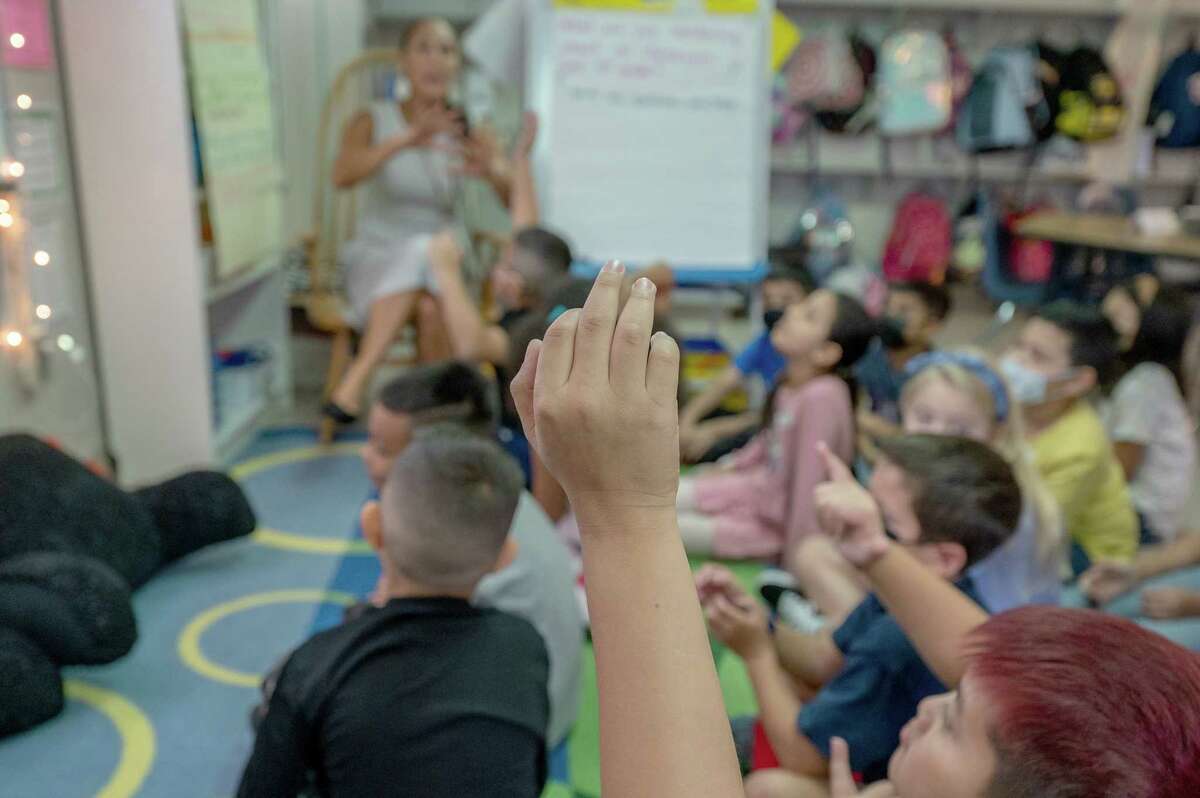 A third grader raises their hand in Springfield, Va., in August 2022.