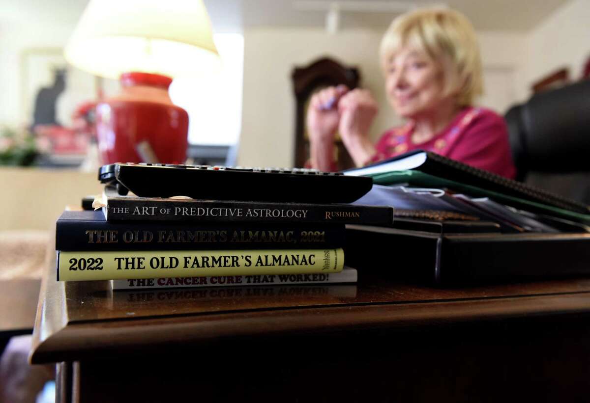 Books are stacked on the desk of Ann Fisher, an Albany-based psychic and hypnotist, at her home office on Thursday, Sept. 29, 2022, in Albany, N.Y.