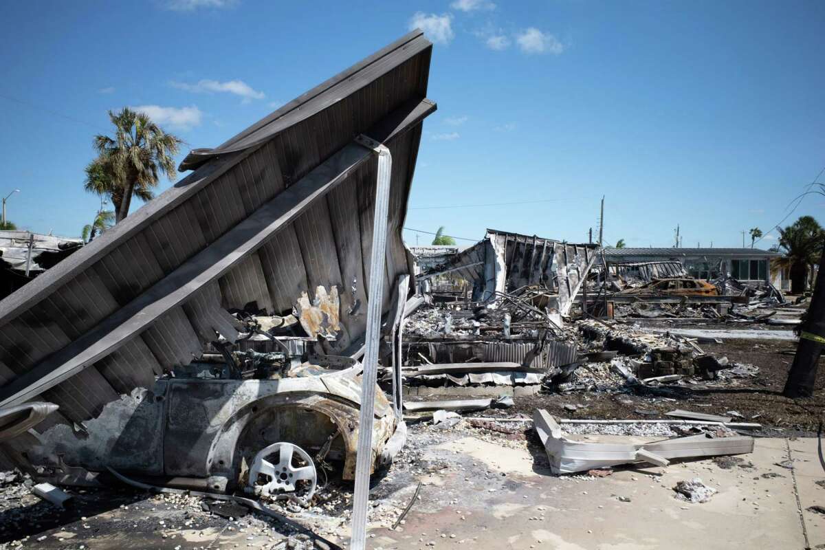Homes and vehicles burn from an electrical fire following Hurricane Ian in Venice, Fla., on Friday.