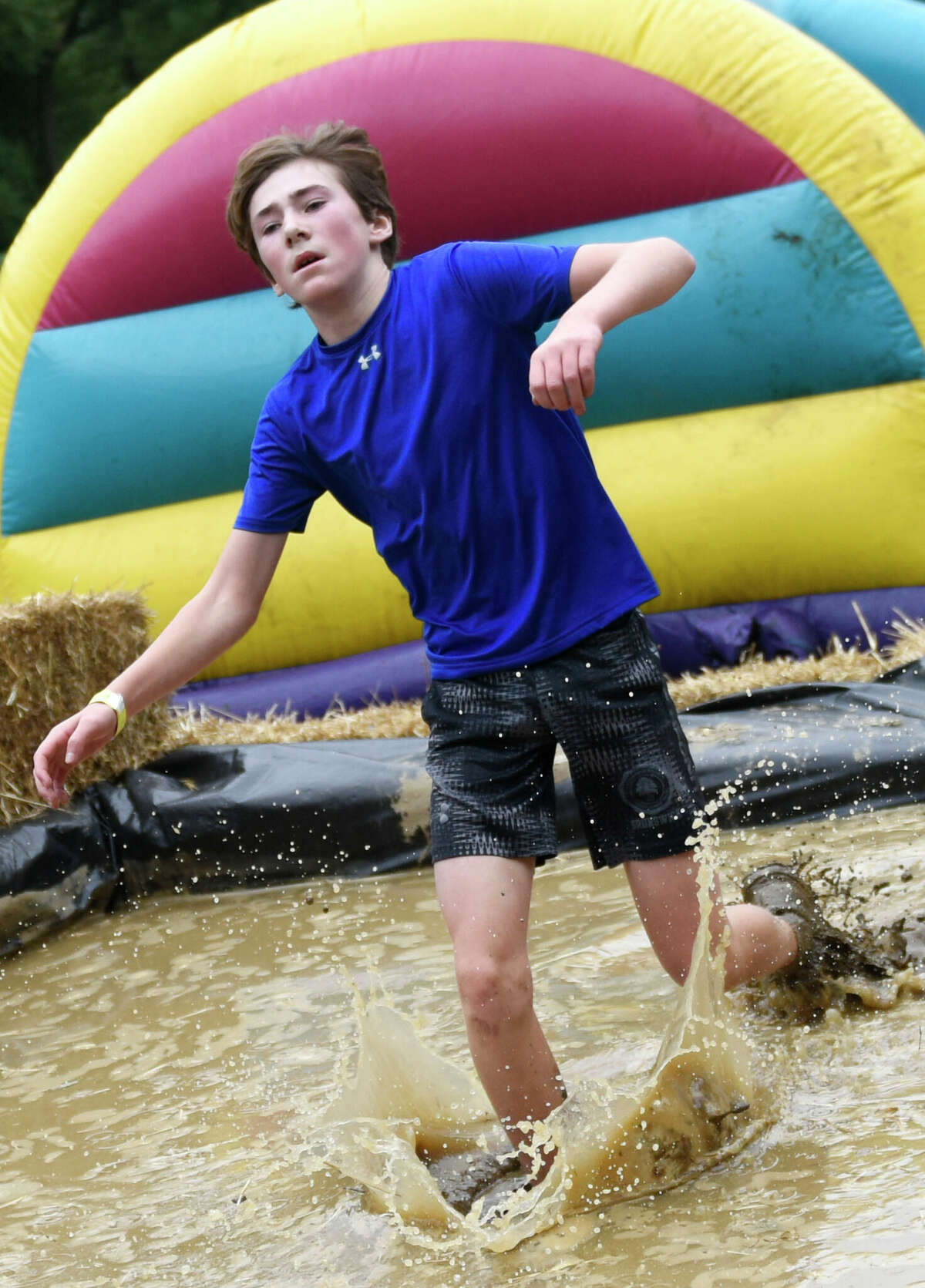 Greenwich's Teddy Hojlo, 14, slogs through the mud to finish in first place overall at the 10th annual Boys & Girls Club of Greenwich Muddy Up 5K run at Camp Simmons in Greenwich, Conn. Sunday, Oct. 2, 2022.