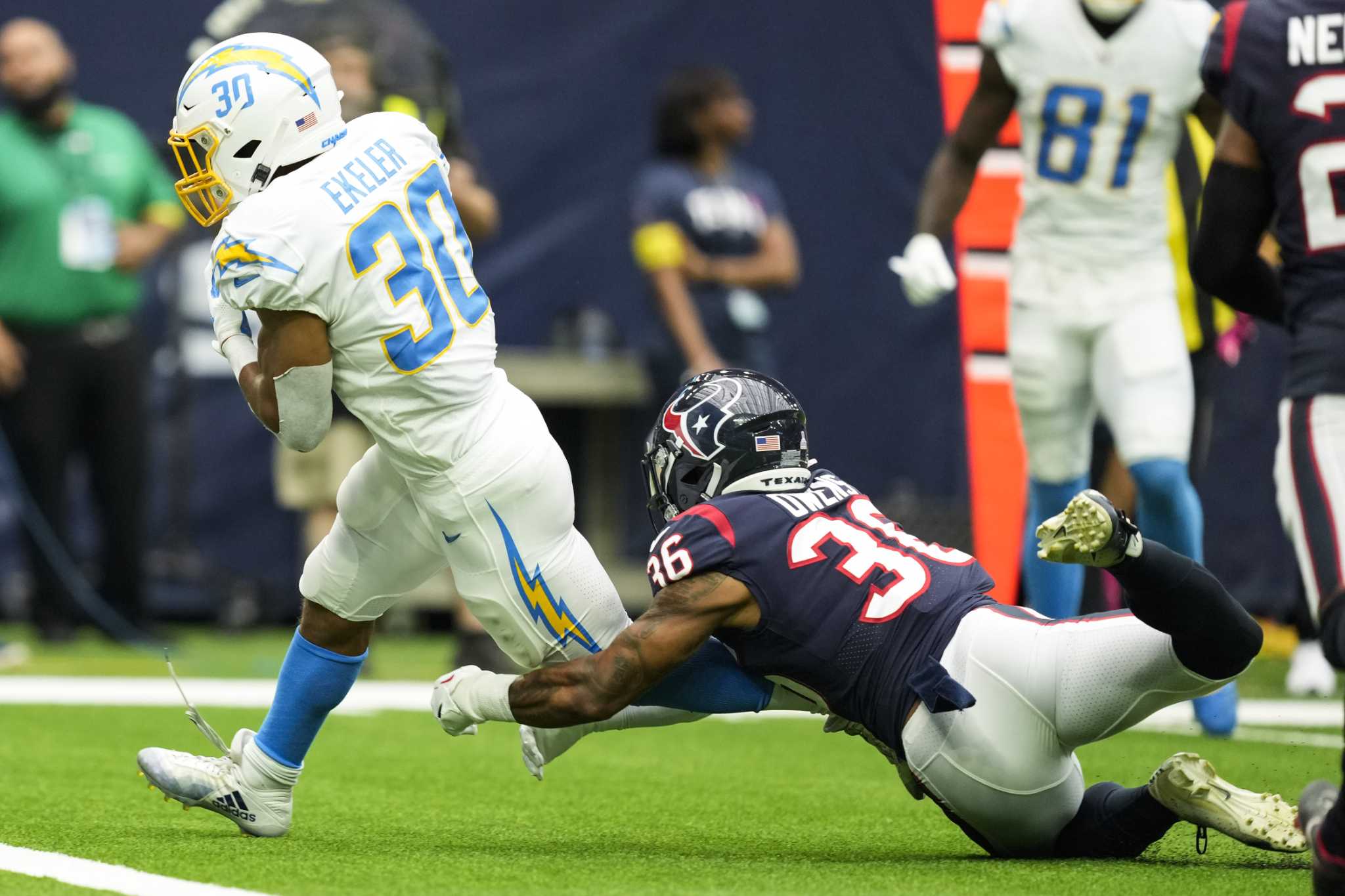 Los Angeles Chargers' Josh Palmer (5) is tackled by Houston Texans' Tremon  Smith (24) during the second half of an NFL football game Sunday, Dec. 26,  2021, in Houston. The Texans won