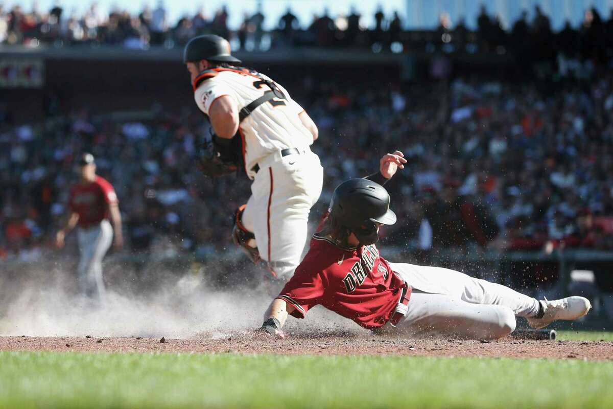SAN FRANCISCO, CALIFORNIA - OCTOBER 02: Jake McCarthy #30 of the Arizona Diamondbacks slides in safely at home plate to score on a double by Josh Rojas #10 in the top of the eighth inning against the San Francisco Giants at Oracle Park on October 02, 2022 in San Francisco, California.(Photo by Lachlan Cunningham/Getty Images)