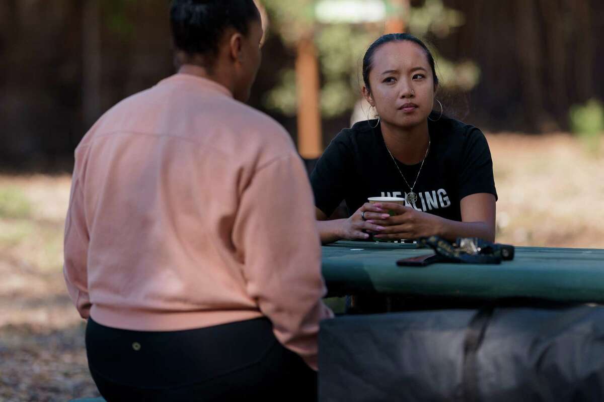 Dr. Bernie Lim, founder of Freedom Community Clinic, talks with a community member at a community healing clinic organized by Freedom Community Clinic in Arroyo Viejo Park in East Oakland, California.
