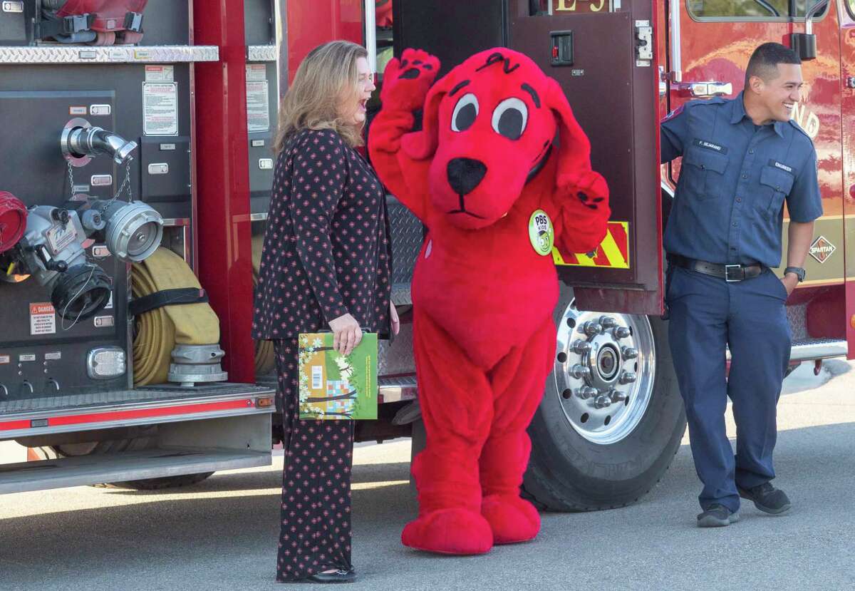 Clifford the Big Red Dog waves to students with MISD Acting Superintendent Kellie Spencer after arriving 10/03/2022 at Pease Communications & Technology Academy for the kick-off event for Project Literacy. Tim Fischer/Reporter-Telegram