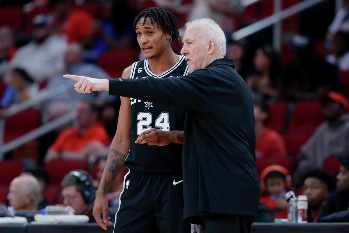 Spurs head coach Gregg Popovich, right, talks with Devin Vassell by the bench during the first half of Sunday’s preseason game against the Houston Rockets.