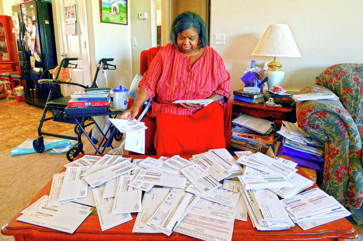 Debra Smith sorts through medical bills in her living room. Medical bills can quickly become overwhelming, but consumers often have more power than they might think when it comes to navigating them.