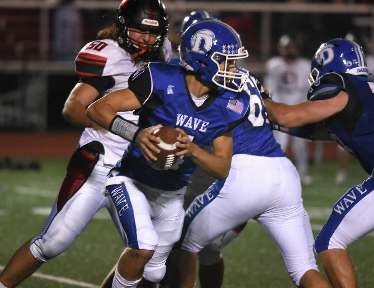 Darien's Simeon Doll (4) scrambles with the ball during a football game against Warde in Fairfield on Friday, Sept. 30, 2022.