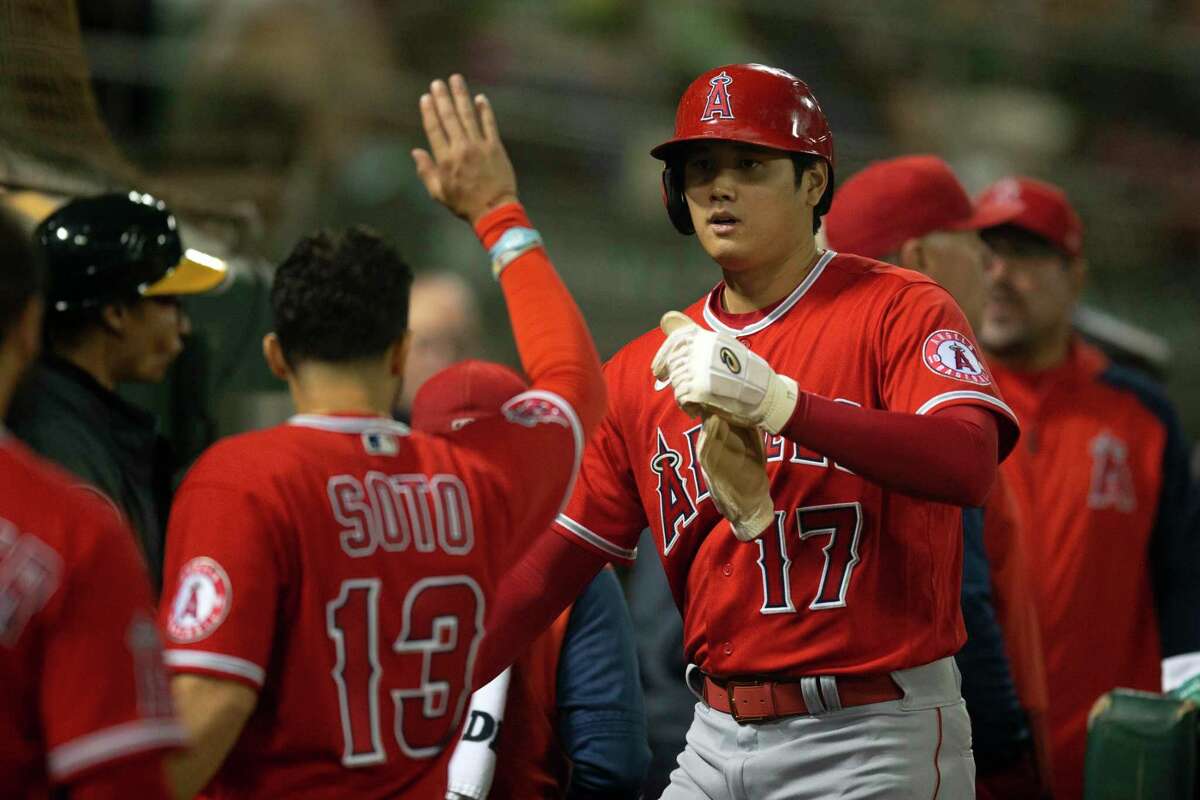 Los Angeles Angels designated hitter Shohei Ohtani(17) is greeted by his teammates after he scored on a double by Taylor Ward during the fifth inning of a baseball game against the Oakland Athletics, Monday, Oct. 3, 2022, in Oakland, Calif.(AP Photo/D. Ross Cameron)