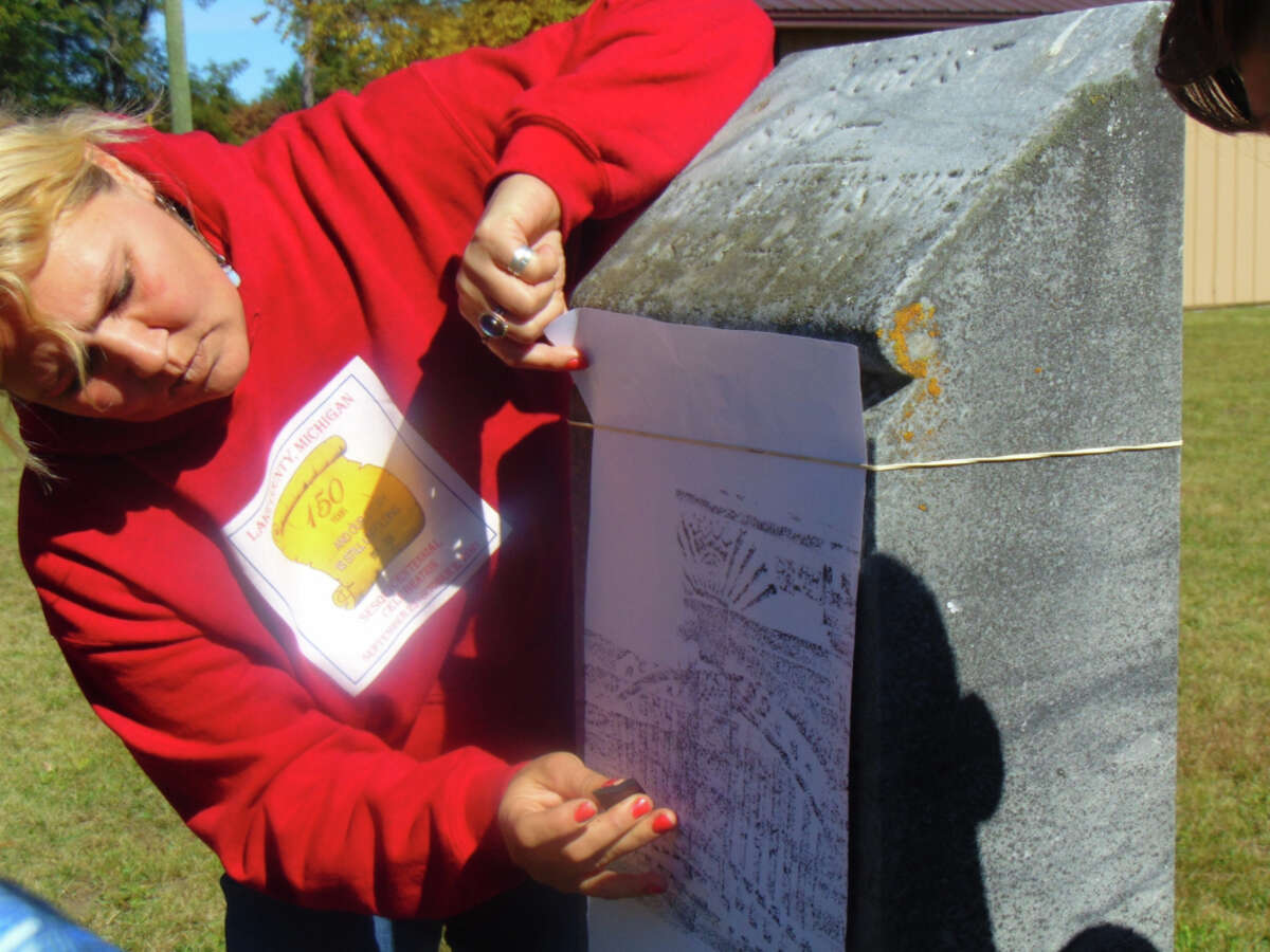 Visitors of the Lake County Historical Society's "Stranger Stop and Cast an Eye" program got to hear the life-stories of the people buried in the Pleasant Plains and Webber Township cemeteries, represented by talented local reenactors. Above, Michele Owens demonstrates the art of gravestone rubbing.