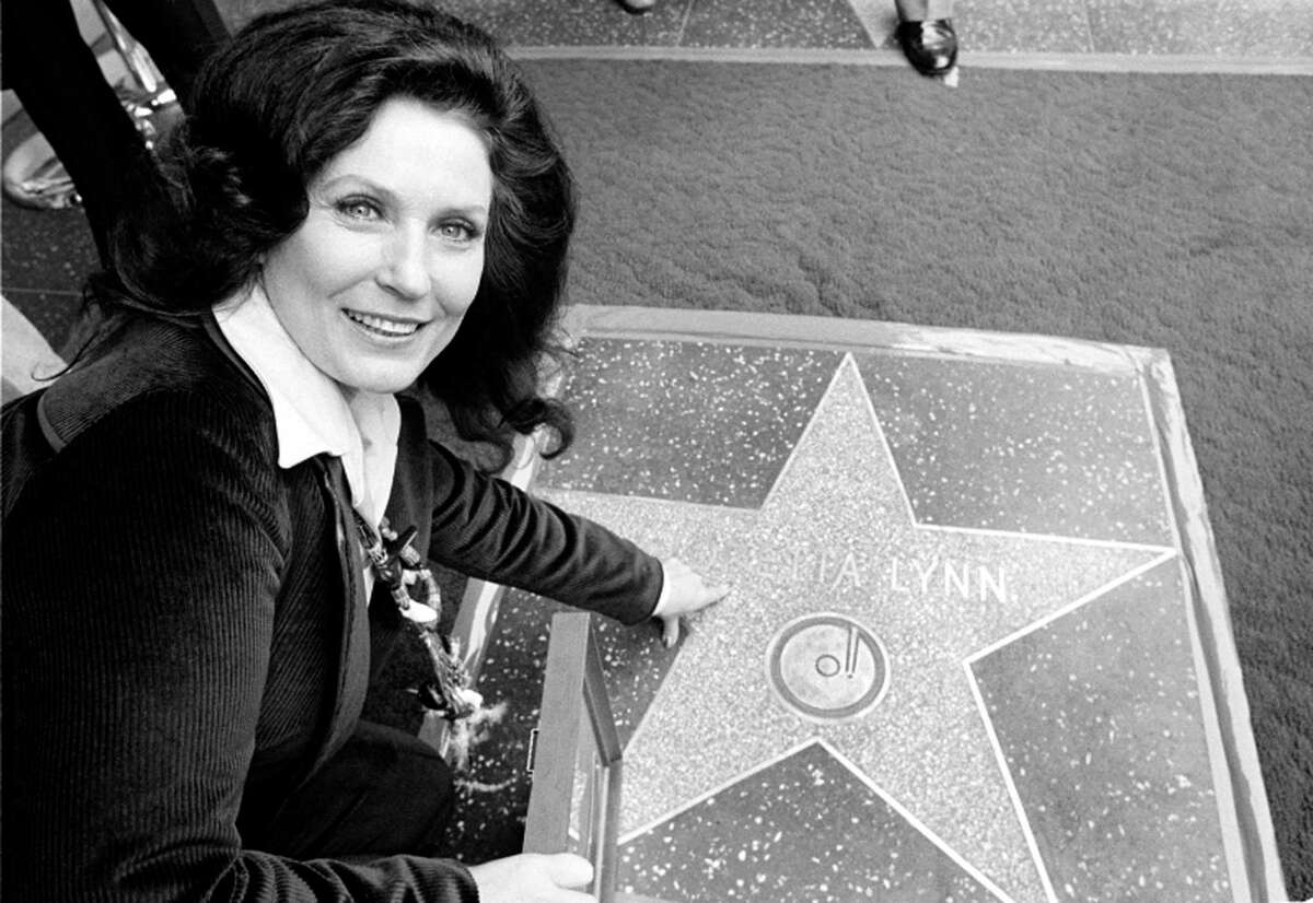 FILE - Country music singer Loretta Lynn points to her Hollywood Walk of Fame star during induction ceremonies in Hollywood, Calif., on Feb. 8, 1978. Lynn, the Kentucky coal miner’s daughter who became a pillar of country music, died Tuesday at her home in Hurricane Mills, Tenn. She was 90.