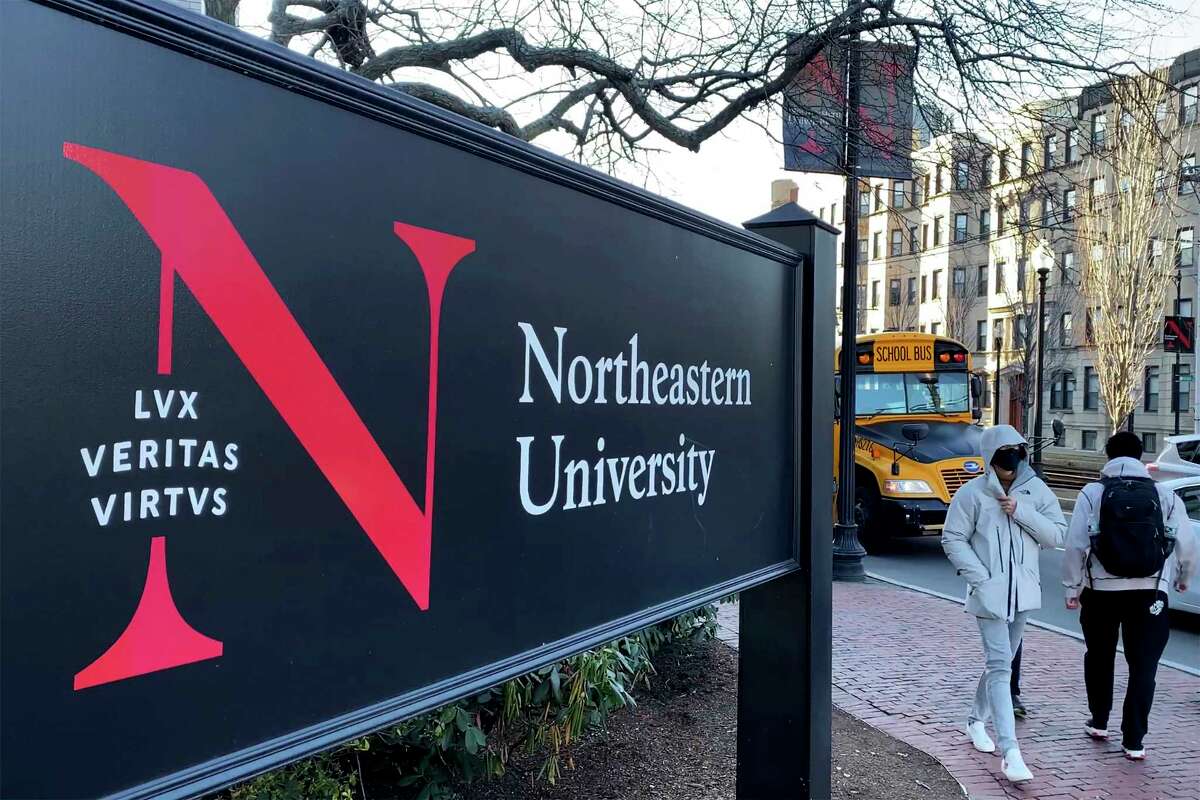 FILE - Students walk on the Northeastern University campus in Boston on Jan. 31, 2019. A Northeastern University employee who said he was injured when a package he was opening on the Boston campus exploded last month was charged Tuesday, Oct. 4, 2022, with fabricating the incident.