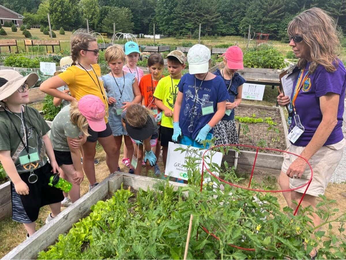 Julia Chambers (right), president of A Few Friends for the Environment of the World, speaks with kids in the U Dig It Community Garden in Ludington. Chambers is a finalist for the Cox Conserves Heroes Groundbreaker Award.