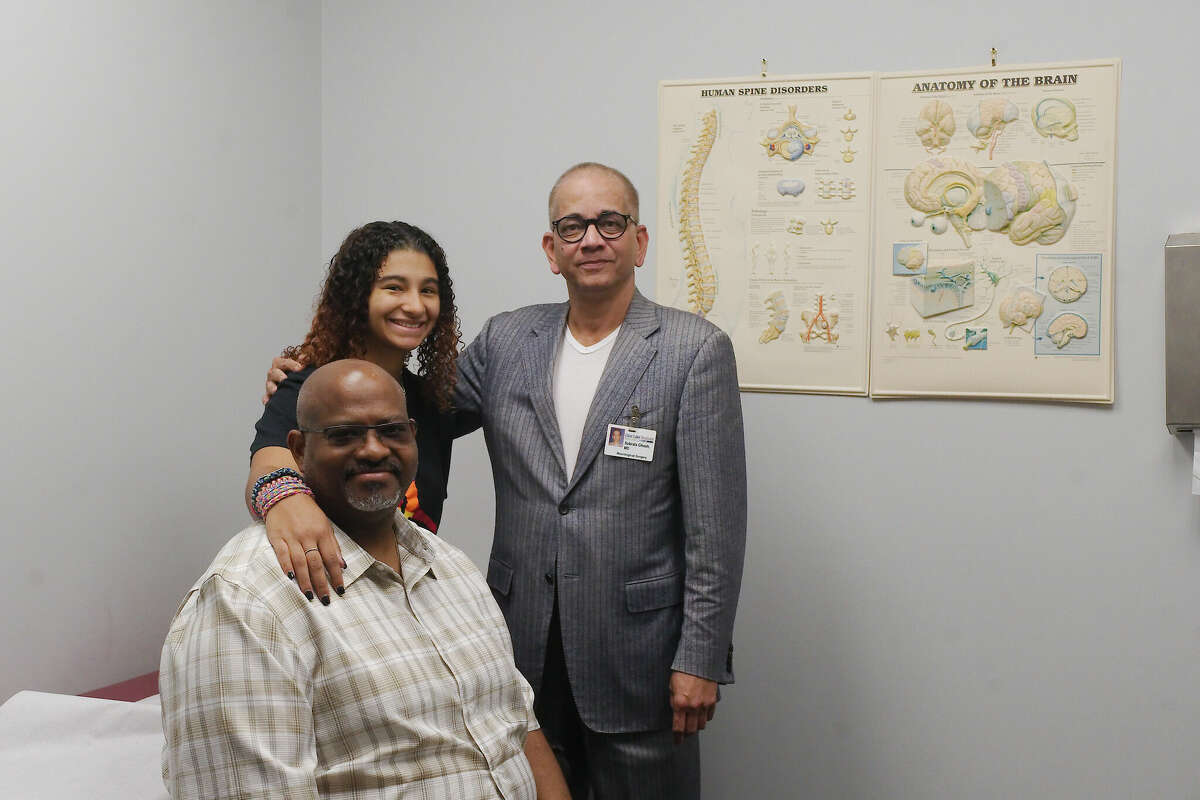 Sylvia House stands with Dr. Subrata Ghosh, right, and her dad Charles. In March, Ghosh removed a benign tumor from her brain that she had lived with for most of her life.