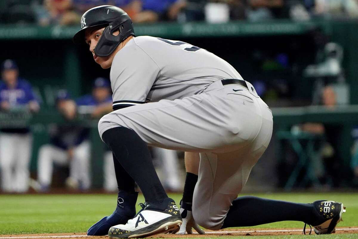 New York Yankees' Aaron Judge ducks down while leading off from third base during eighth inning in the first baseball game of a doubleheader against the Texas Rangers in Arlington, Texas, Tuesday, Oct. 4, 2022.