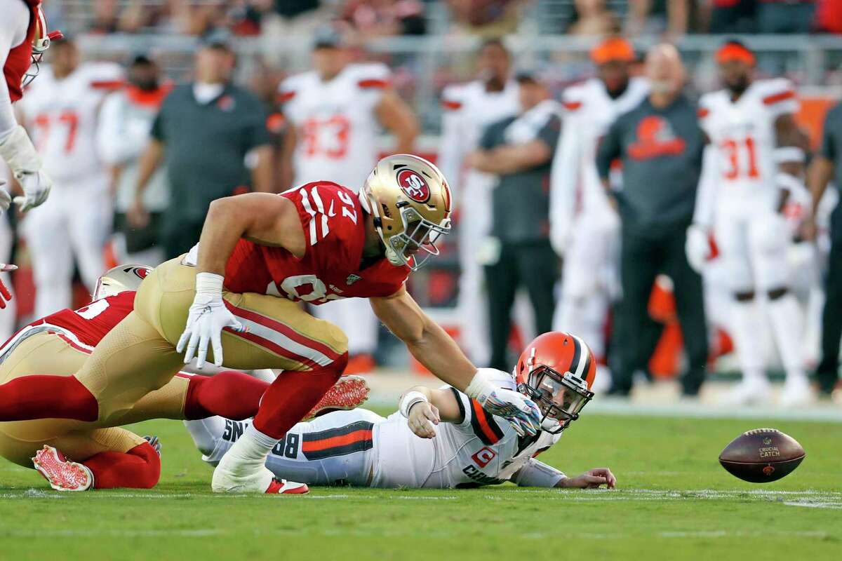 San Francisco 49ers defensive players hit a goal post with a logo