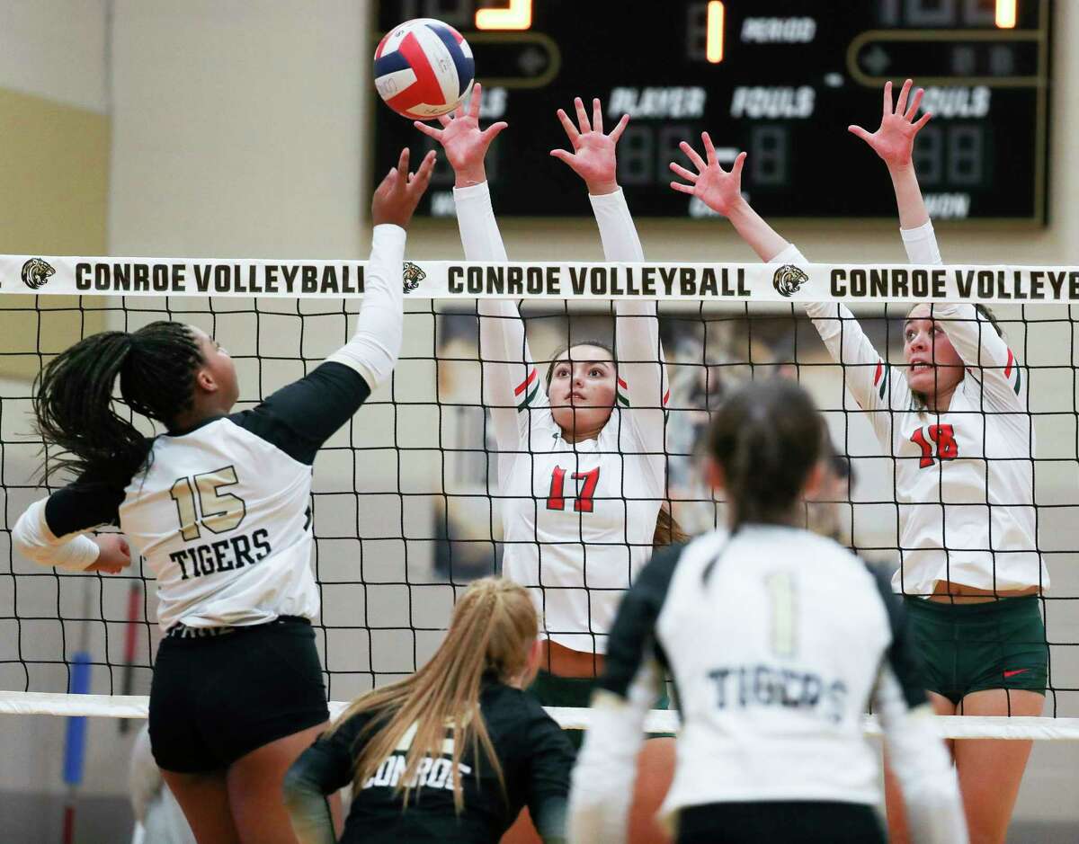The Woodlands' Claire DeWine (17) and Sophie Jones (18) pressure a tip by Conroe’s Ariana Brown (15) in the first set of a District 13-6A high school volleyball match at Conroe High School, Tuesday, Oct. 4, 2022, in Conroe.