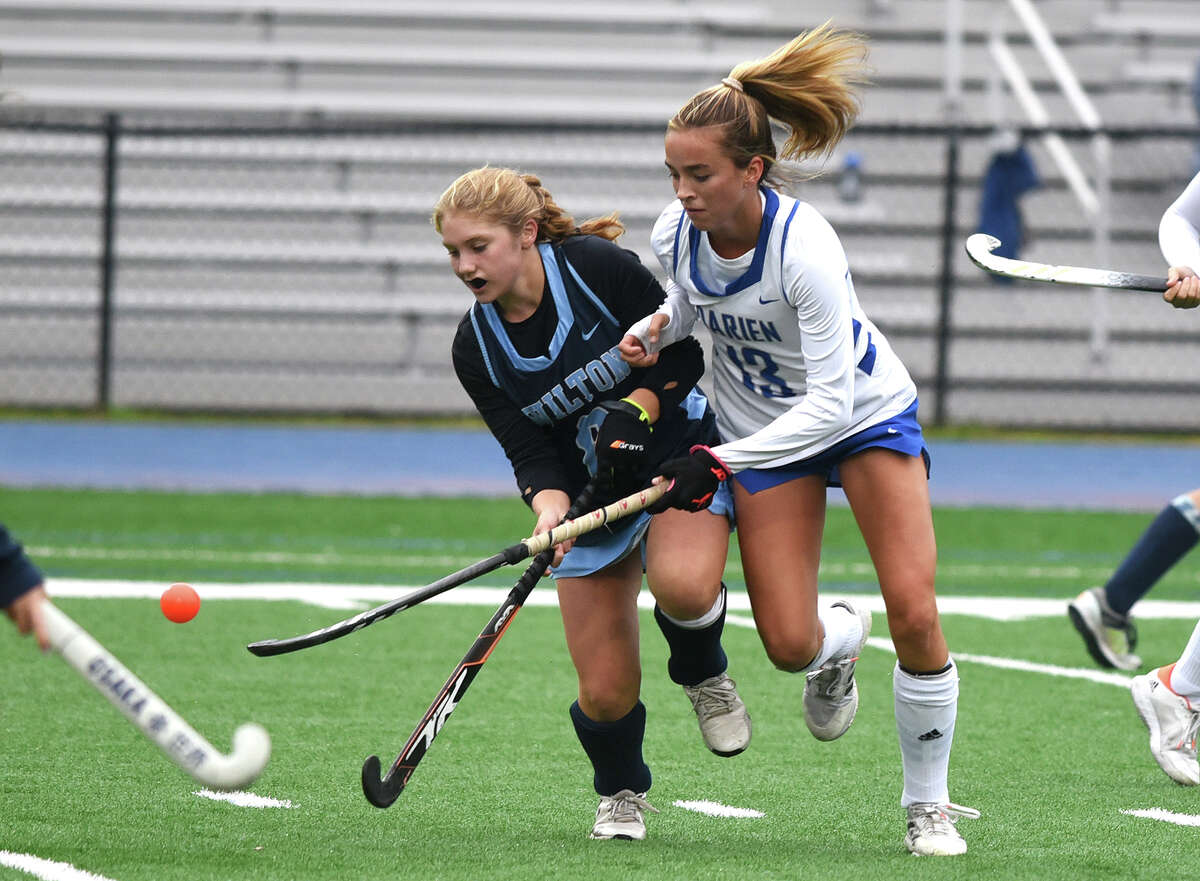 Wilton's Katherine Costanzo (8) and Darien's Ashley Stockdale (13) battle for the ball during a field hockey game in Darien on Tuesday, Oct. 4, 2022.
