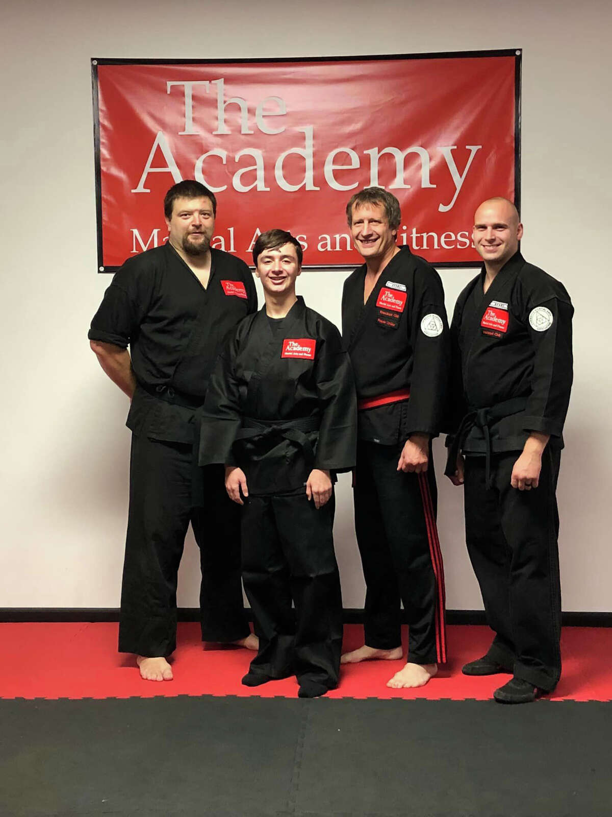 Jonah Bright (second from left) poses with The Academy instructors (from left) Ben Stacy, Craig Sira, and Jacob Sira after earning his black belt recently.