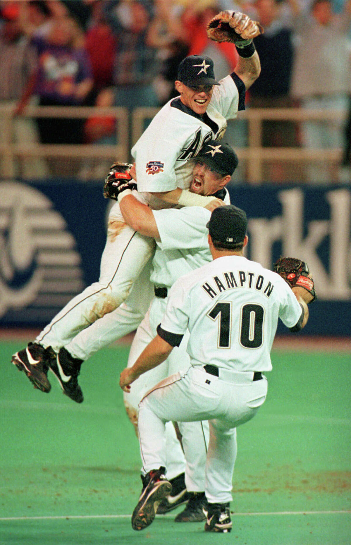 Astros first baseman Jeff Bagwell hoists Craig Biggio as Mike Hampton joins the celebration.