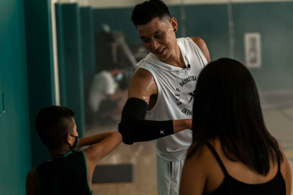 Jeremy Lin bumps elbows with 11-year-old Brandon Ho, the oldest of Alan Ho's three sons who have been mentored by Lin.