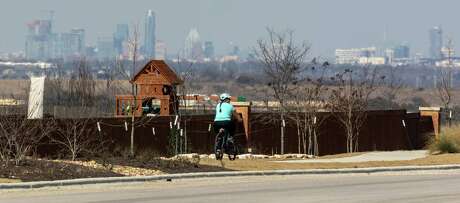 The Austin skyline sits beyond a bicyclist as she rides along Sunfield Parkway east of Interstate 35 in Buda. A 3.7-mile gap exists in Buda between where State Highway 45 ends at FM 1626 and then begins again at Interstate 35. If the gap is closed, it essentially would create a traffic loop around Austin.