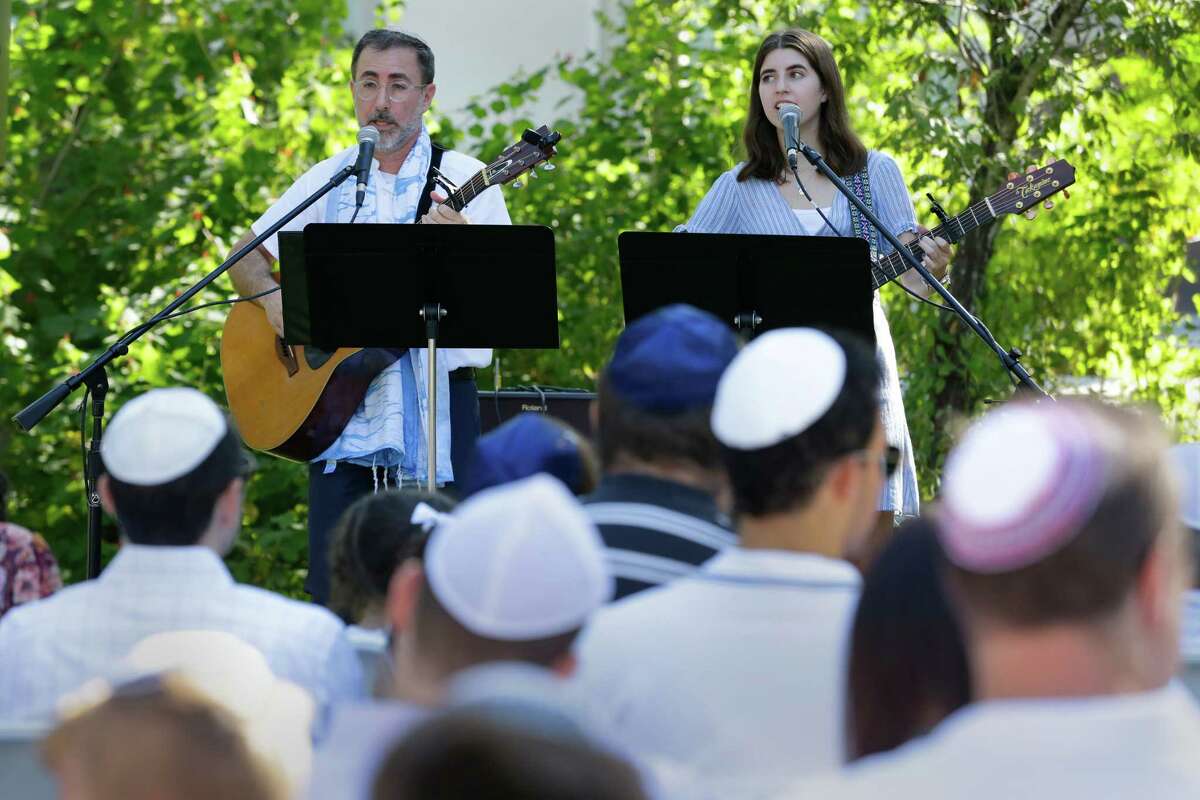 Rabbi Ranon Teller and his daughter, Nava, lead songs for the congregation at a service Wednesday during the observance of Yom Kippur by members of Congregation Brith Shalom synagogue at the Nature Discover Center.