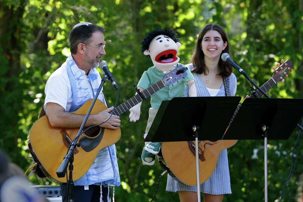 Rabbi Ranon Teller and his daughter, Nava, use puppets as they lead a service Wednesday during the observance of Yom Kippur by members of Congregation Brith Shalom at the Nature Discover Center.