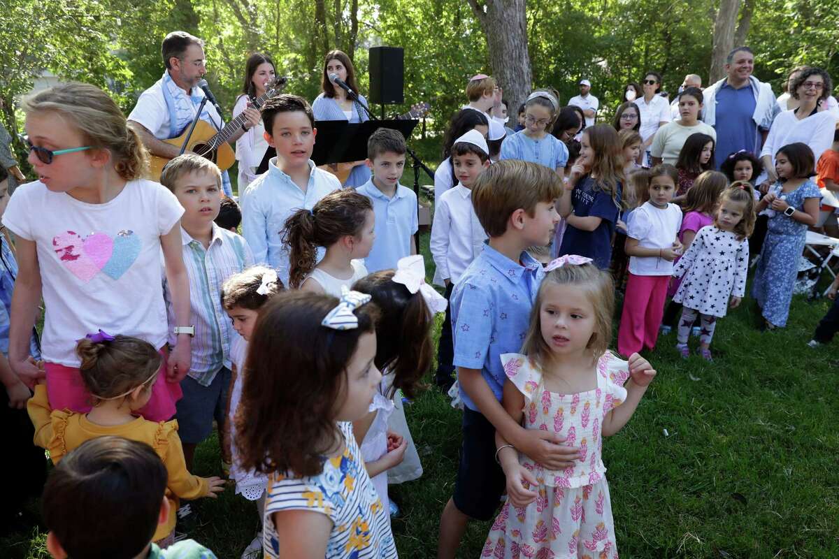 Children come to the front to sing during a service Wednesday in the observance of Yom Kippur by members of Congregation Brith Shalom at the Nature Discover Center.