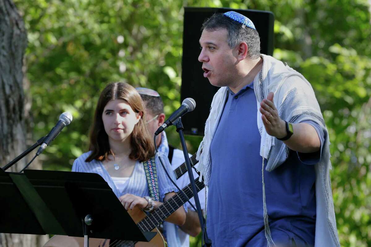 Jonah Paranaski, president of Brith Shalom synagogue, right, address the congregation as Nava Teller listens during a service in the observance of Yom Kippur on Wednesday at the Nature Discover Center.