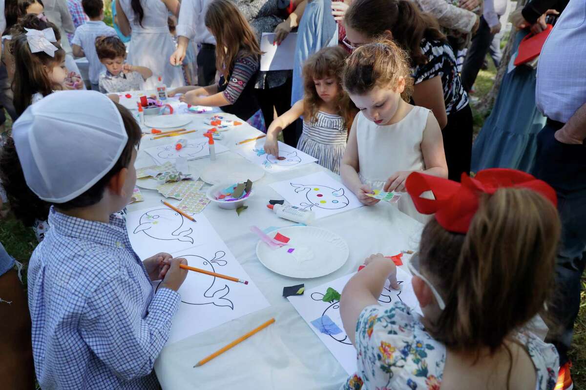 Children make crafts of Jonah and the whale after a service Wednesday during the observance of Yom Kippur by members of Congregation Brith Shalom synagogue at the Nature Discover Center.