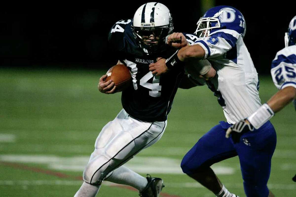 Wilton punt returner Clay Helms fight for extra yardage against a Darien defender during second half action at Wilton.