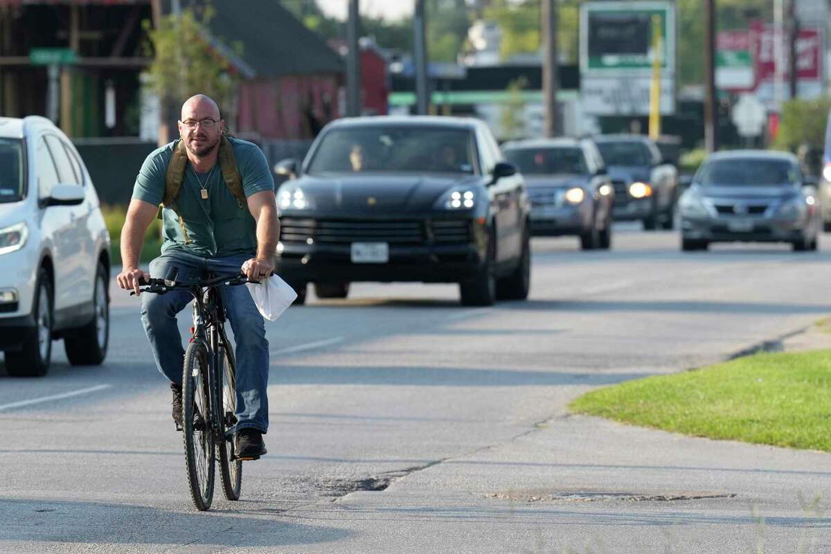 A cyclist rides on the side of the road along N. Shepherd on Sept. 12, 2022 in Houston. Despite passing a law more than nine years ago requiring drivers to give cyclists at least three feet of space, Houston police have cited only 64 drivers. 