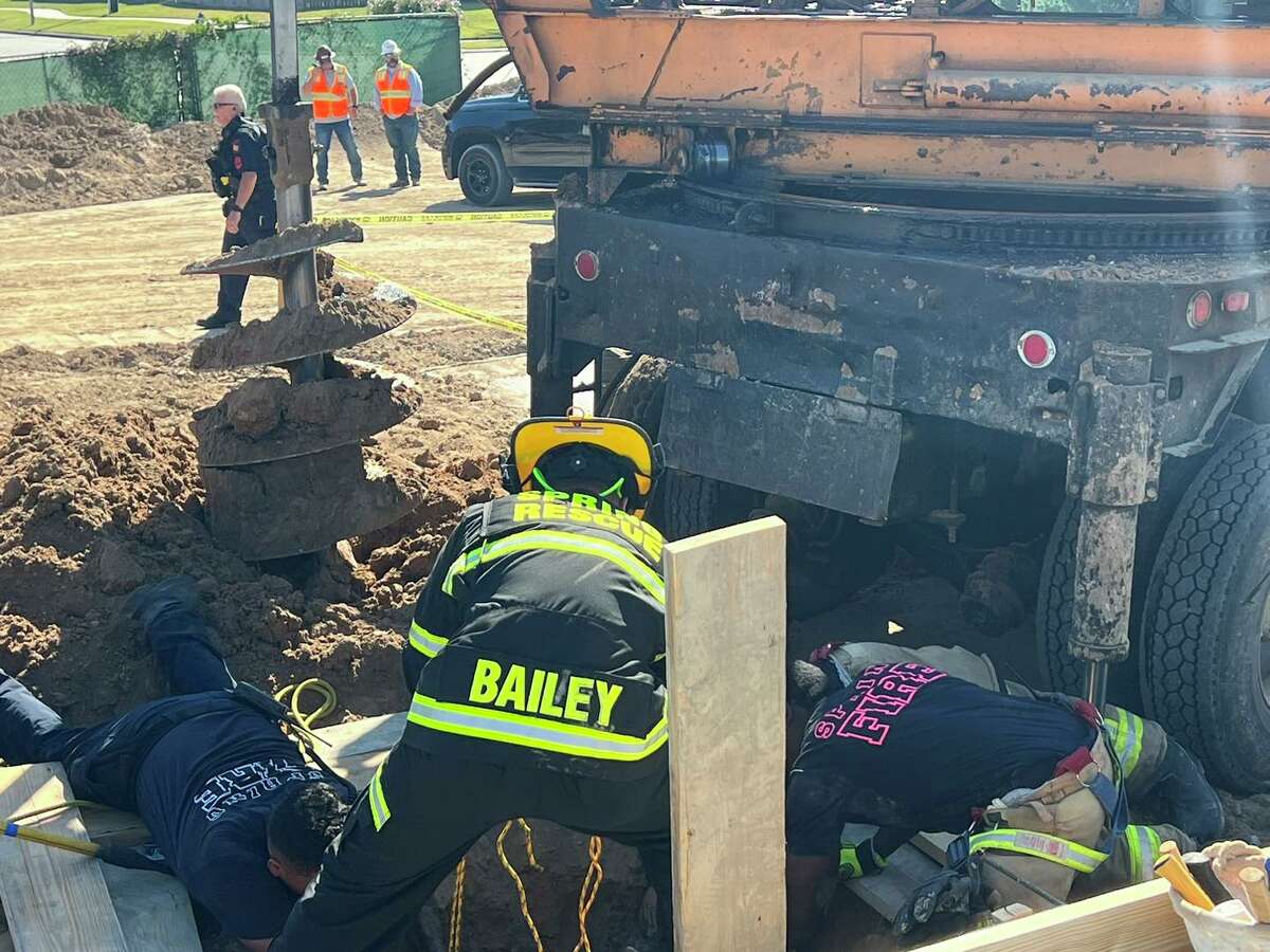 Firefighters from the Spring Fire Department work around the hold where a 22-year-old man was killed in an industrial accident on Wednesday, Oct. 5, 2022.  